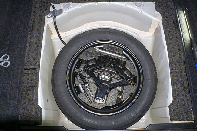 Photograph of Hopkins plug in vehicle wiring harness with 4 pole connector inside 2010 Subaru Outback, showing wiring running underneath the car's spare tire.